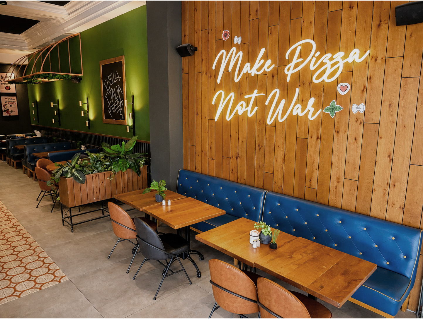“Make Pizza Not War” neon lettering on the wood feature wall, Ramat Gan